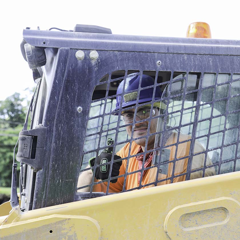 person operating machinery giving thumbs up