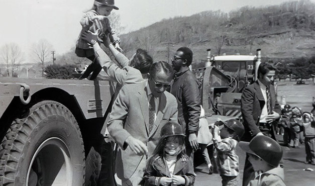 children wearing hard hats next to adult chaperones