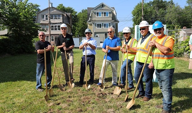 group of people posing with shovels
